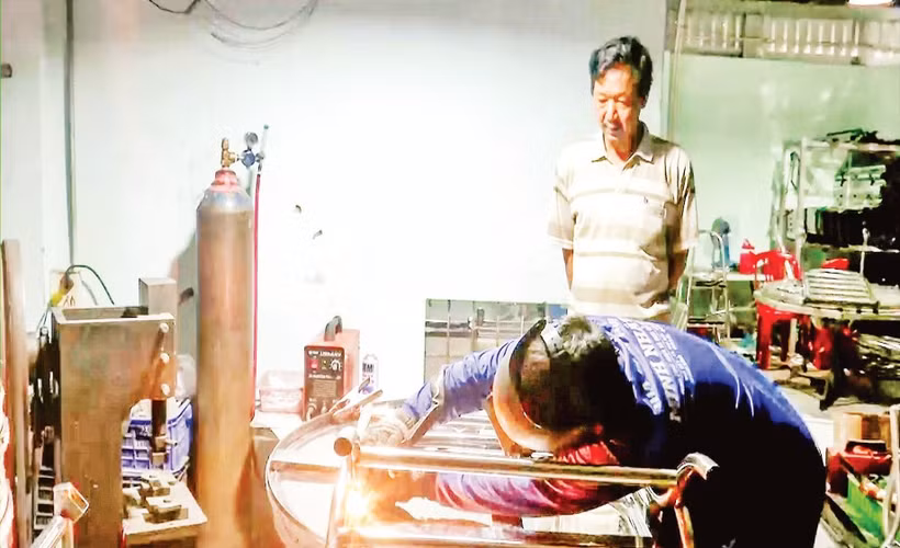 Ông Nguyễn Văn Kiệt quan sát thợ hàn thực hiện công đoạn hoàn thiện sản phẩm.