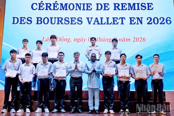 Phó Chủ tịch Quỹ học bổng Vallet Espéran Padonou và Phó Chủ tịch Ủy ban nhân dân tỉnh Lâm Đồng Nguyễn Minh trao học bổng tặng các sinh viên. (Ảnh: BẢO VĂN)
