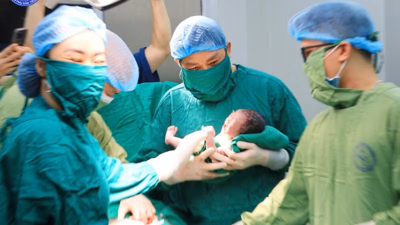 Giáo sư, Tiến sĩ Nguyễn Duy Ánh, Giám đốc Bệnh viện Phụ sản Trung ương thực hiện cắt dây rốn chậm cho em bé. 