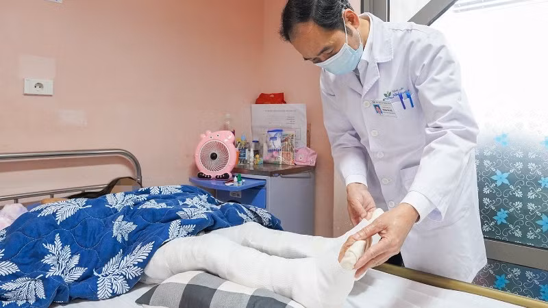 Tiến sĩ, bác sĩ Hoàng Hải Đức, Trưởng khoa Chỉnh hình thăm khám cho bệnh nhi sau phẫu thuật.
