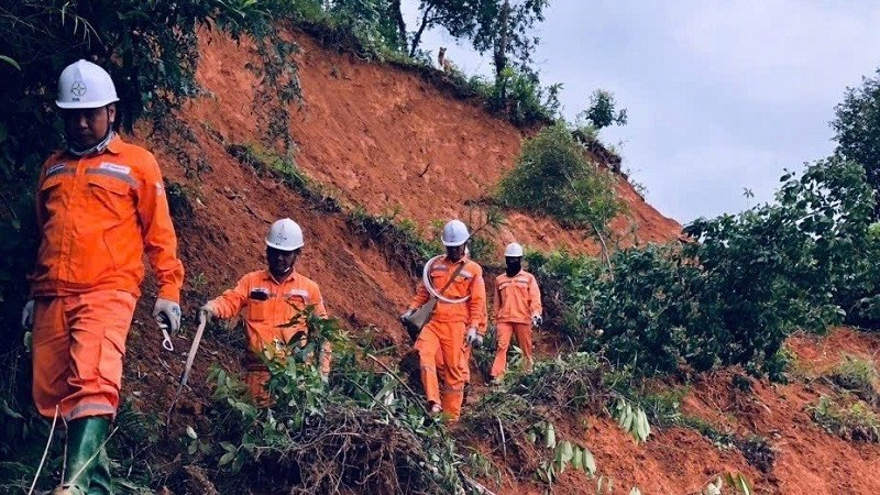 Công nhân Công ty Điện lực Điện Biên đi bộ vượt núi khắc phục sự cố do lũ quét.