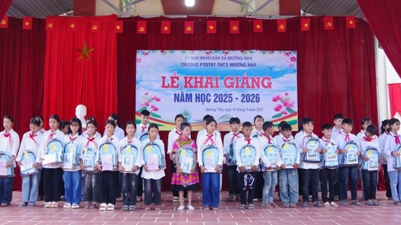 Cán bộ Đồn Biên phòng Cửa khẩu Huổi Puốc và Mường Nhà tặng quà tặng học sinh trong Dự án “Cán bộ, chiến sĩ Quân đội nâng bước em tới trường”. (Ảnh: ANH DŨNG)