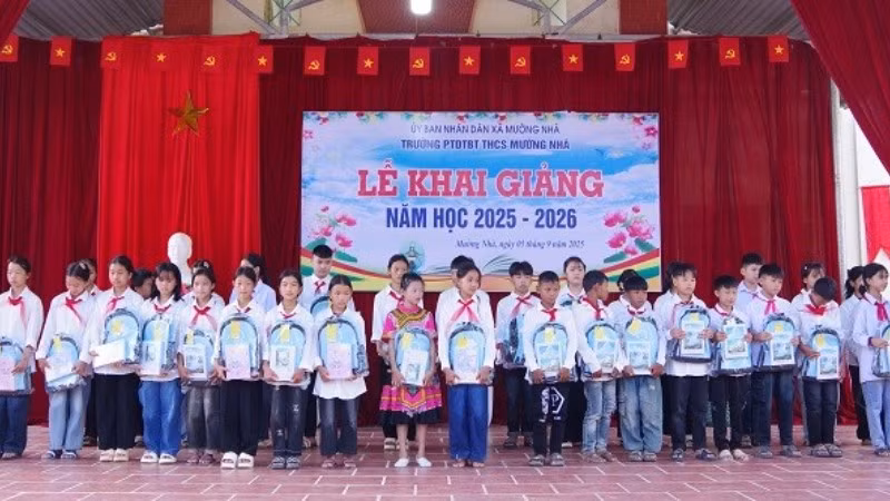 Cán bộ Đồn Biên phòng Cửa khẩu Huổi Puốc và Mường Nhà tặng quà tặng học sinh trong Dự án “Cán bộ, chiến sĩ Quân đội nâng bước em tới trường”. (Ảnh: ANH DŨNG)