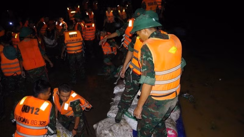 Bộ đội Sư đoàn 325 tích cực gia cố đê sông Cầu thuộc địa bàn xã Tam Giang. (Ảnh: QUANG ĐẠO)