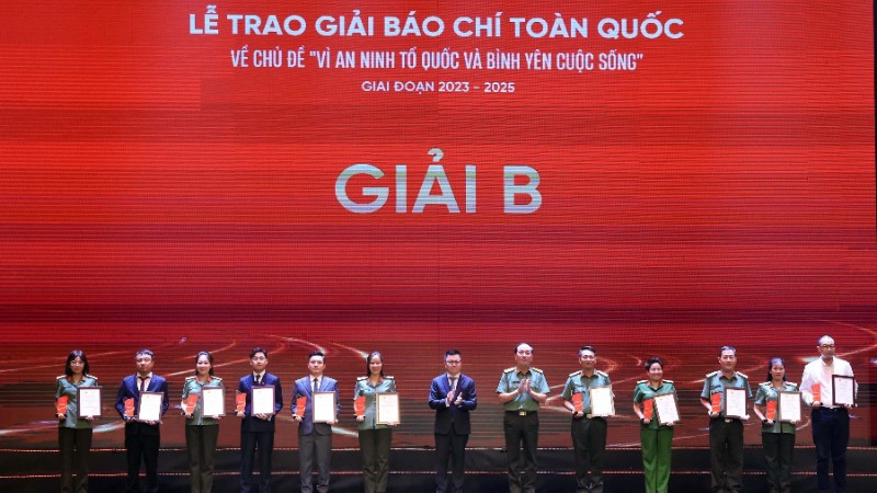 Đồng chí Lê Quốc Minh, Uỷ viên Trung ương Đảng, Phó Trưởng Ban Tuyên giáo và Dân vận Trung ương, Tổng Biên tập Báo Nhân Dân, Chủ tịch Hội Nhà báo Việt Nam và Thượng tướng Trần Quốc Tỏ, Uỷ viên Trung ương Đảng, Thứ trưởng Bộ Công an trao giải Nhì cho các tác giả, đại diện nhóm tác giả. Ảnh: TUẤN ANH/TTXVN