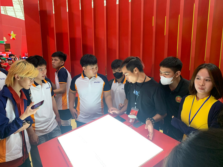 Các bạn trẻ trải nghiệm sách tương tác "Biên niên sử Đảng". z6999492791999-bb5c017f6dbf39a2b0099cd583f4a3f0.jpg