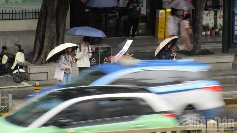 Người dân đứng chờ xe bus ở Thâm Quyến, Trung Quốc. (Ảnh: THANH THỂ)