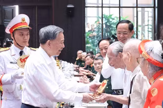 Tổng Bí thư Tô Lâm tặng quà cho cán bộ lão thành cách mạng. (Ảnh: TTXVN)