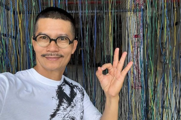 Họa sĩ Nguyễn Ngọc Dân tại triển lãm trưng bày tác phẩm của anh.