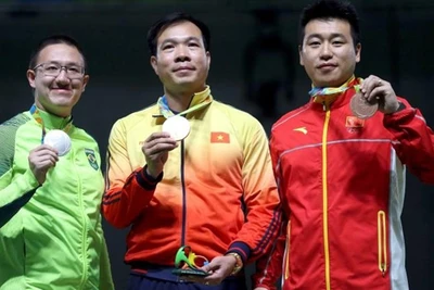 Hoàng Xuân Vinh (ở giữa) trên bục nhận huy chương. (Ảnh: Reuters)