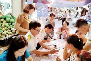 Công chức Thuế thành phố Hà Nội tuyên truyền, hỗ trợ hộ kinh doanh chuyển đổi sang phương pháp kê khai, nộp thuế. Ảnh: gdt.gov.vn