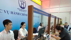 Điểm phục vụ hành chính công Hoàng Mai (Hà Nội), các chuyên viên nhiệt tình hướng dẫn người dân làm thủ tục. (Ảnh HẢI MIÊN)