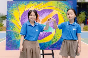 Các em học sinh bên bức tranh “Chấm & Chạm” của dự án. (Ảnh ĐÔNG THI)