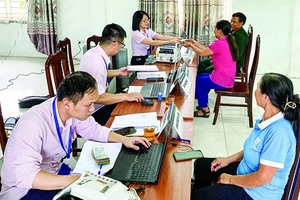 Cán bộ Ngân hàng Chính sách xã hội chi nhánh Hà Nội giải ngân vốn vay cho người dân tại Điểm giao dịch. (Ảnh VBPS)