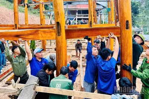 Lực lượng công an và các tổ chức đoàn thể hỗ trợ người dân xã biên giới Nhôn Mai dựng nhà mới sau thiên tai (Ảnh: PHAN TUYẾT)
