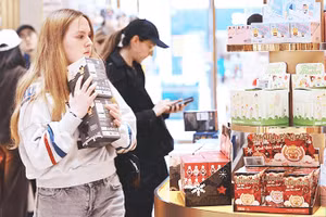 Người dân mua sắm hàng hóa tại một cửa hàng ở London. Ảnh: XINHUA