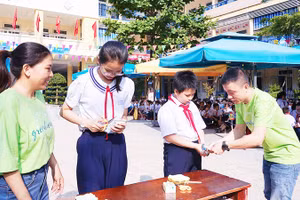 Cô và trò cùng thu gom, vệ sinh vỏ hộp sữa sau khi sử dụng.