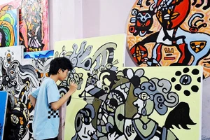 Hoàng Nhật Quang bên tác phẩm của mình.