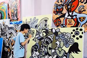 Hoàng Nhật Quang bên tác phẩm của mình.