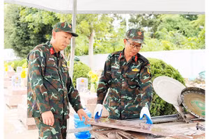 Trung tá Ngọc (bên phải) cùng đồng đội thao tác với chiếc máy mòi đá do anh sáng chế.