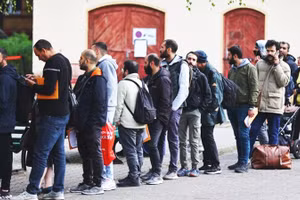 Người tị nạn chờ được cấp phép nhập cảnh tại biên giới Đức. Ảnh: AFP