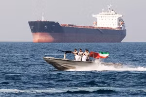 Lực lượng an ninh Iran tuần tra cạnh một tàu hàng ở Eo biển Hormuz. Ảnh: GETTYIMAGES