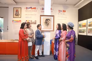 Nhà báo Huỳnh Dũng Nhân (thứ ba, trái sang) giới thiệu bức vẽ kỷ vật gia đình trao tặng Bảo tàng Phụ nữ Việt Nam.