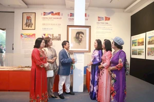 Nhà báo Huỳnh Dũng Nhân (thứ ba, trái sang) giới thiệu bức vẽ kỷ vật gia đình trao tặng Bảo tàng Phụ nữ Việt Nam.