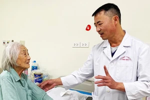 ThS, bác sĩ CKII Kiều Quốc Hiền, Trưởng Khoa A9 (Bệnh viện E) thăm hỏi, hướng dẫn bệnh nhân cao tuổi phục hồi sau mổ. 