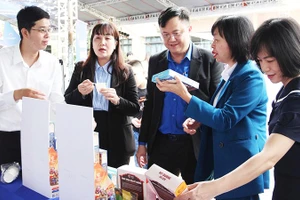 Trương Văn An (bên trái), giới thiệu sản phẩm của CaThiFood đến người tiêu dùng.