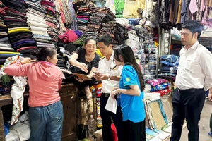 Doanh nghiệp cung cấp giải pháp công nghệ phối hợp với Thuế Hải Phòng trực tiếp xuống chợ hỗ trợ tiểu thương. Ảnh KỲ DUYÊN