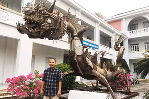 Họa sĩ Đinh Thanh Hải bên tác phẩm “Con rồng sắt” của nhà điêu khắc Pháp Marc Morvan, làm bằng phế liệu vỏ bom đạn, inox sau chiến tranh, hiện đặt tại sân Trường đại học Khánh Hòa.
