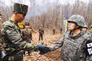 Quan chức quân đội Hàn Quốc (bên phải) và Triều Tiên bắt tay tại khu phi quân sự (DMZ). Ảnh: REUTERS