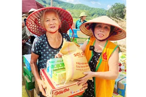 Bà Nguyệt đi phát gạo cho người dân vùng ngập nước.