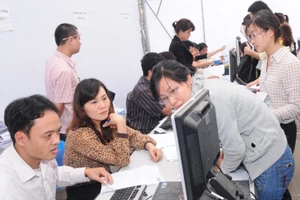 Hướng dẫn doanh nghiệp kê khai tại Thuế thành phố Hà Nội. Ảnh: NAM ANH