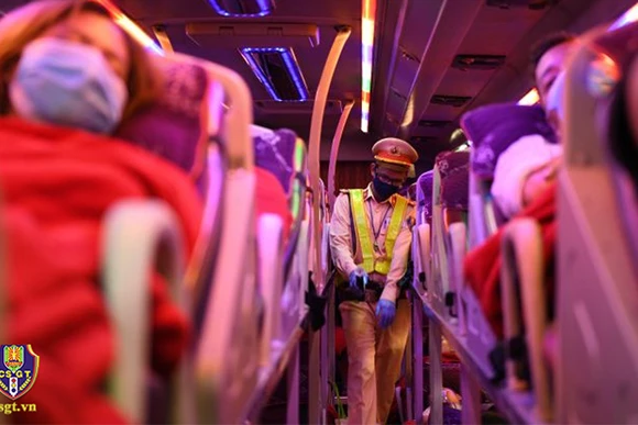 Chiến sĩ cảnh sát giao thông nhắc nhở hành khách trên xe thắt dây an toàn. (Ảnh: Cục CSGT)