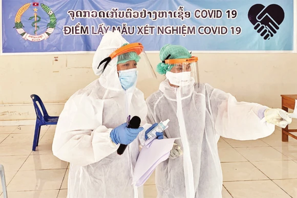 Bà Huyền (trái) tại một điểm xét nghiệm Covid-19. 