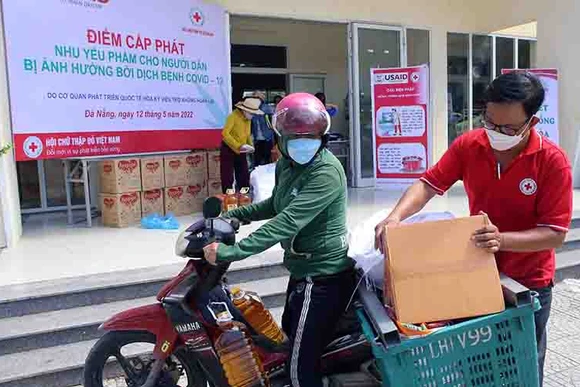 Hỗ trợ người dân mang nhu yếu phẩm về.