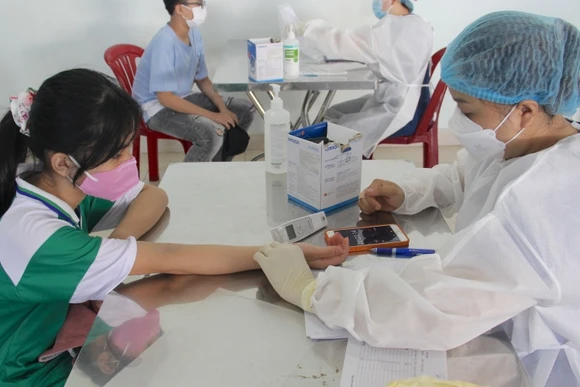 Các em được khám sàng lọc trước khi tiêm vaccine.