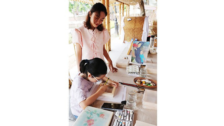 Trẻ vẽ tranh lụa tại lễ hội “Lớn lên cùng truyền thống”. Ảnh: K.MINH