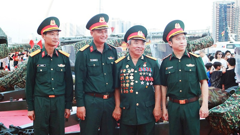 Cựu chiến binh Dương Đình Tấu (thứ 2 từ phải qua) trò chuyện cùng cán bộ, chiến sĩ đội pháo lễ.