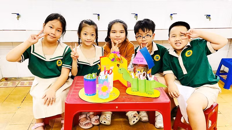 Học sinh Trường tiểu học Lê Lợi (TP Huế) bên các sản phẩm tái chế từ đồ đã qua sử dụng.