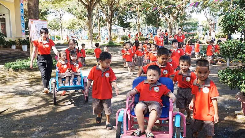 Giáo viên mầm non cùng các bé trong một buổi hoạt động ngoài trời.