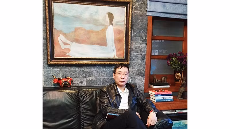 Nhà sưu tầm Hoàng Anh Tuấn bên tác phẩm của họa sĩ Dương Bích Liên.