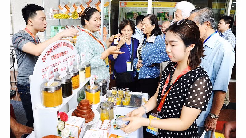 Doanh nghiệp giới thiệu sản phẩm được chiết xuất từ nghệ tại triển lãm y - dược. Ảnh: NAM ANH
