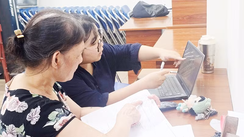 Hướng dẫn người dân cập nhật dữ liệu đất đai tại cụm dân cư. Ảnh: NGUYỆT ANH
