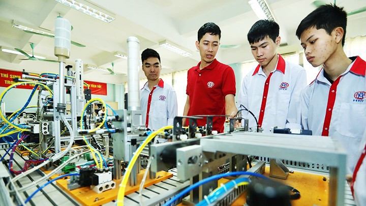 Thầy Cao Hồng Long, (áo sẫm) Trường cao đẳng nghề Công nghệ cao Hà Nội, giới thiệu mô hình tự động hóa cho sinh viên Lớp điện tử công nghiệp K13.