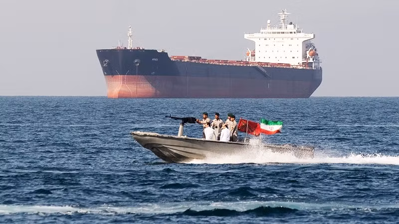 Lực lượng an ninh Iran tuần tra cạnh một tàu hàng ở Eo biển Hormuz. Ảnh: GETTYIMAGES