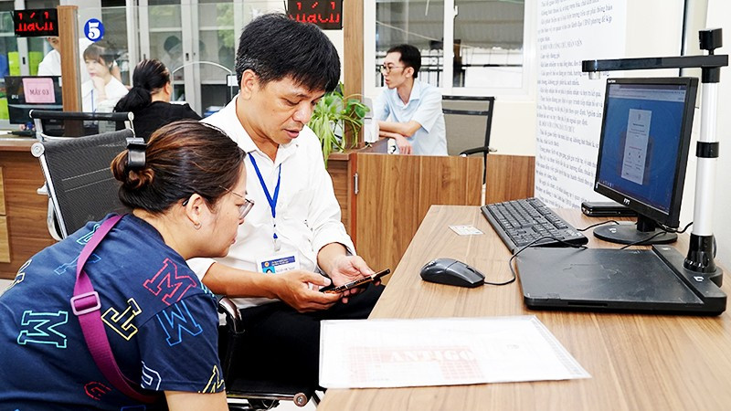Hướng dẫn người dân sử dụng VNeID để làm thủ tục hành chính tại phường, xã. Ảnh: BẮC SƠN