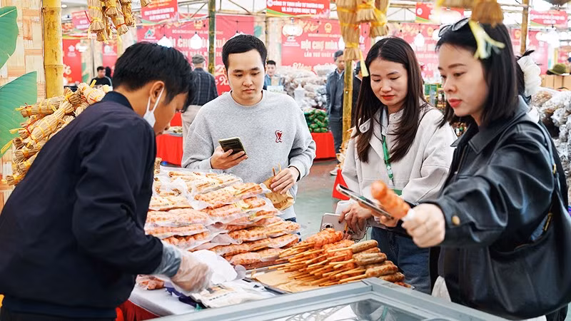 Khách hàng dùng điện thoại di động để truy xuất nguồn gốc thực phẩm. Ảnh: NGUYỆT ANH